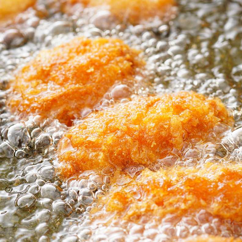 Cibi impanati che friggono nell'olio