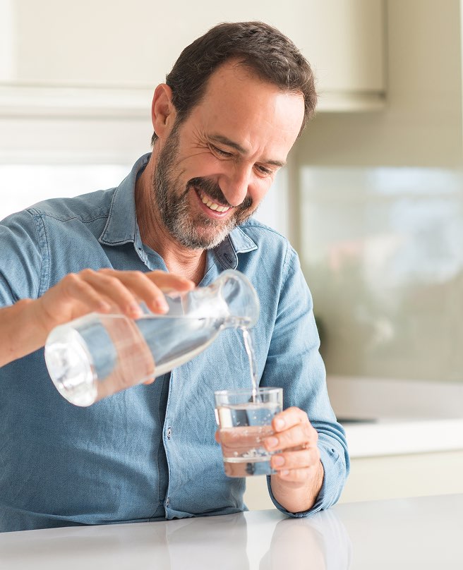 Uomo versa bicchiere acqua